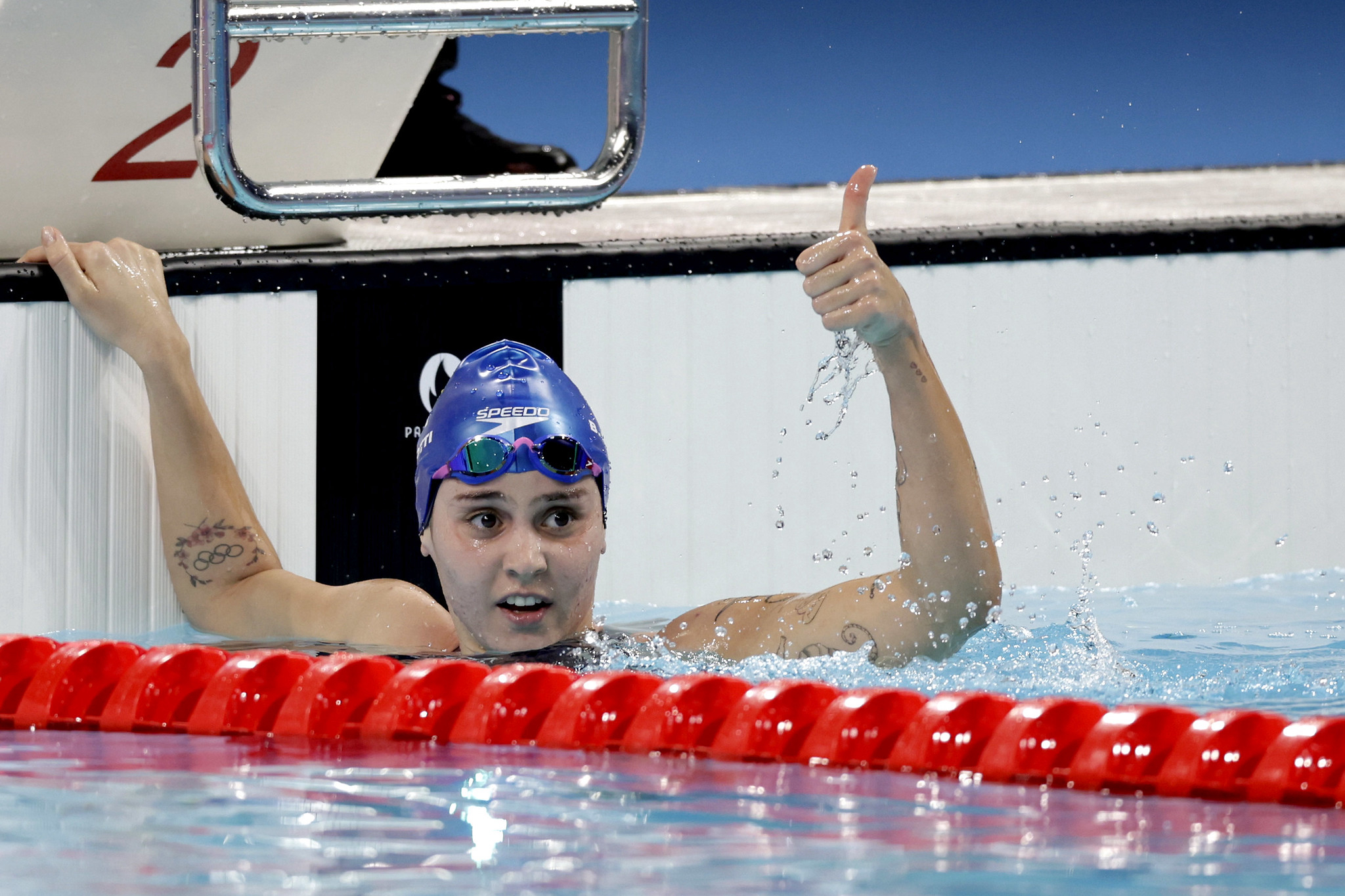 Beatriz Dizotti faz sinal de positivo dentro da piscina após prova de natação