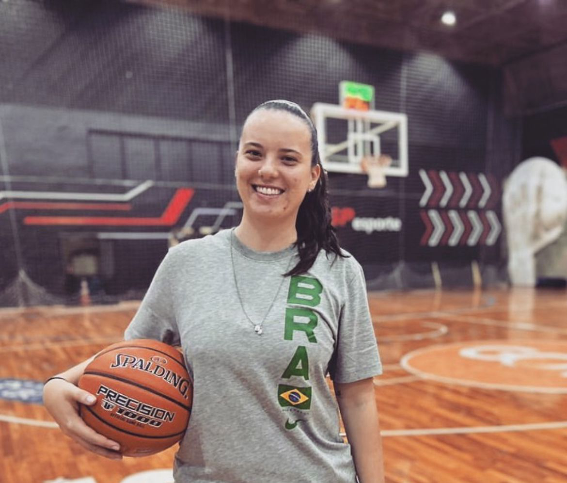 Bruna Rodrigues segura bola de basquete em uma quadra